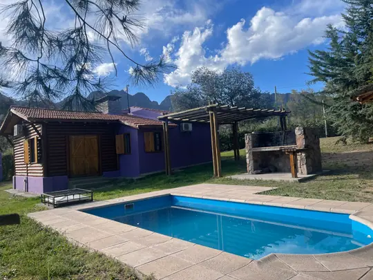 Cabaña Borgoña y su piscina bajo un cielo con nubes