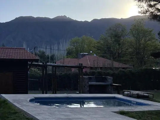 Cabaña Malbec: vista panorámica con techo de tejas y la montaña detrás