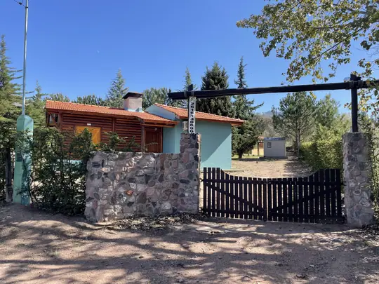 Cabaña Merlot: ingreso con tranquera y muro de piedra